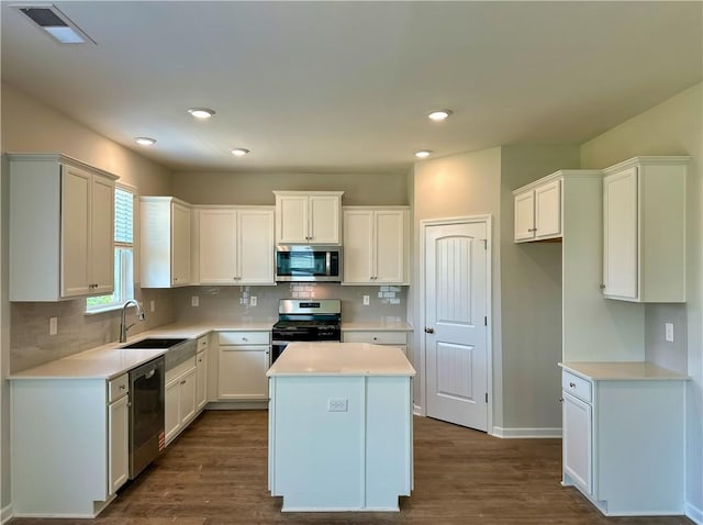 2260 Red Tail Ln, Auburn, AL 36879 - kitchen with appliances with stainless steel finishes, a sink, dark wood-style flooring, a kitchen island, and decorative backsplash