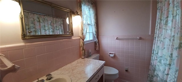 full bathroom featuring vanity, a shower with curtain, wainscoting, tile walls, and toilet