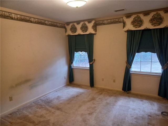 unfurnished room with carpet, visible vents, and baseboards