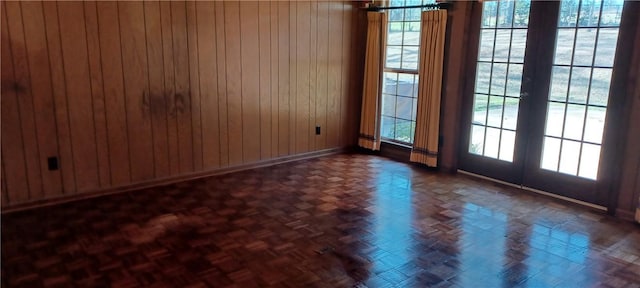 unfurnished room with baseboards and wood walls