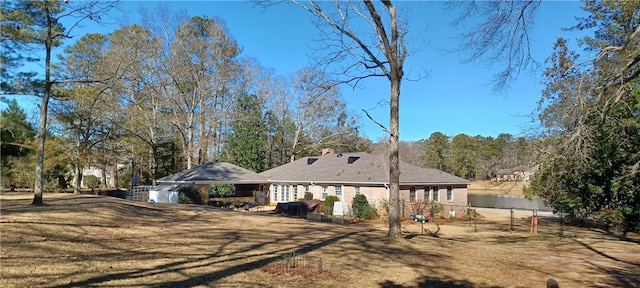 rear view of house with a yard and fence