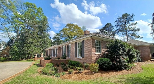 2104 Oak Bowery Rd, Opelika, AL 36801 - view of home's exterior with brick siding, a chimney, and a lawn