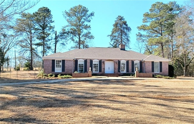 ranch-style house with brick siding and a chimney