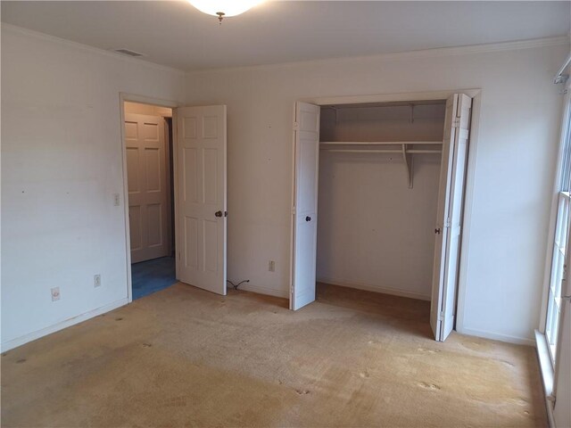 unfurnished bedroom with a closet, visible vents, crown molding, and baseboards