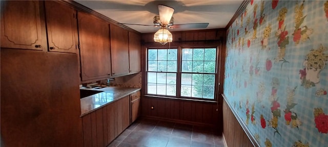 kitchen with light countertops, light tile patterned floors, brown cabinets, and ceiling fan