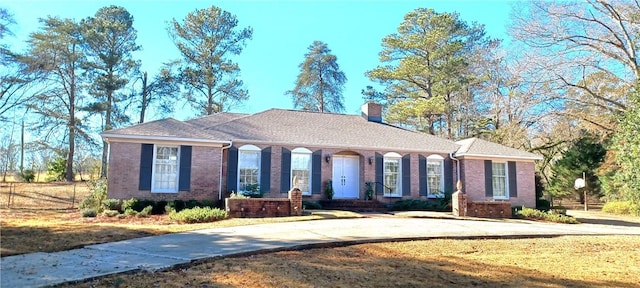 view of front of house featuring brick siding and a chimney