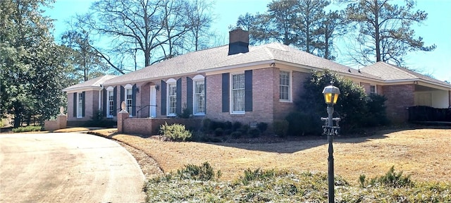 view of front of home featuring brick siding and a chimney