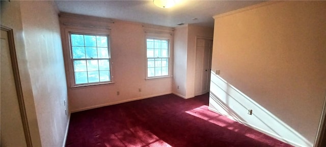 unfurnished bedroom featuring dark colored carpet and baseboards