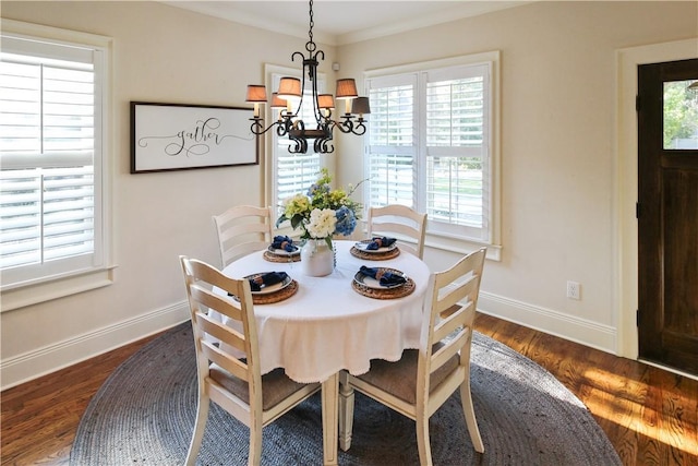 dining area featuring dark hardwood / wood-style flooring, an inviting chandelier, and ornamental molding