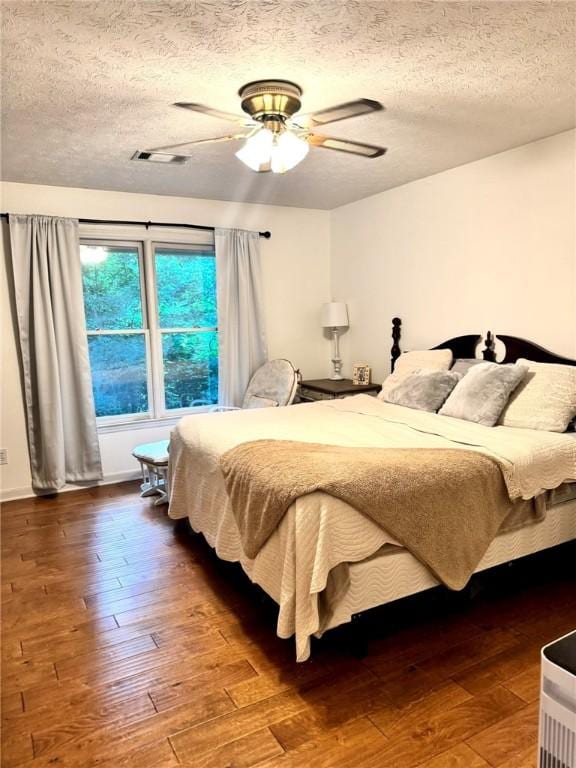 1377 E University Dr, Auburn, AL 36830 - bedroom featuring a textured ceiling, wood-type flooring, and a ceiling fan