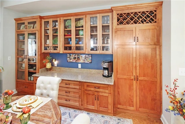 3403 Double Eagle Ln, Opelika, AL 36801 - kitchen with light stone countertops, glass insert cabinets, and baseboards