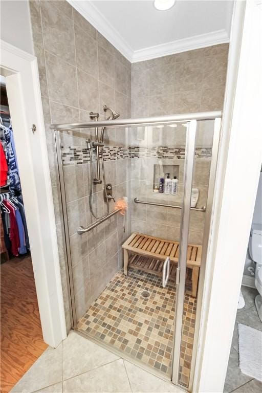 3403 Double Eagle Ln, Opelika, AL 36801 - full bathroom with a stall shower, ornamental molding, a walk in closet, toilet, and tile patterned floors