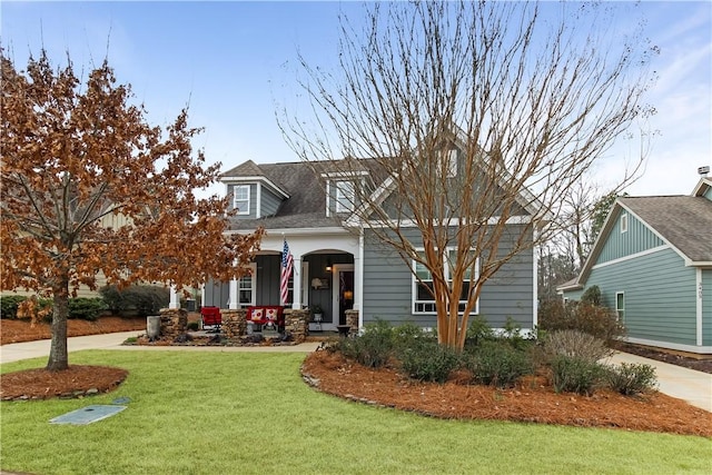 cape cod-style house featuring covered porch and a front yard