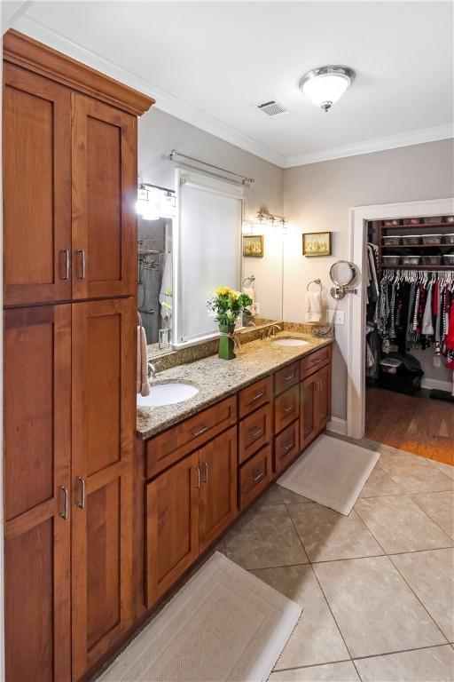 3403 Double Eagle Ln, Opelika, AL 36801 - bathroom with crown molding, double vanity, tile patterned floors, and a spacious closet