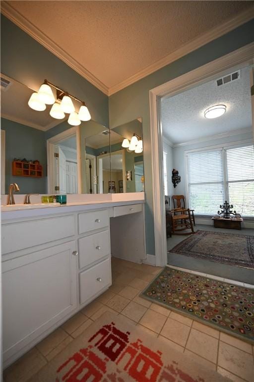 bathroom featuring tile patterned flooring, vanity, ornamental molding, a textured ceiling, and visible vents