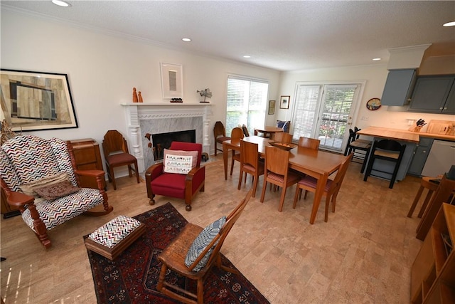 dining area with a fireplace, recessed lighting, and ornamental molding