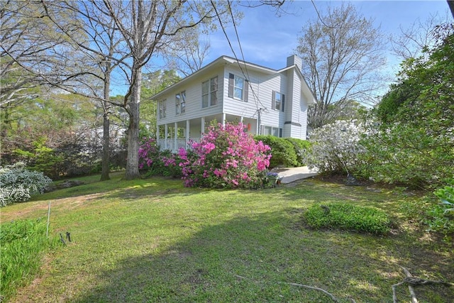 exterior space with a chimney and a yard