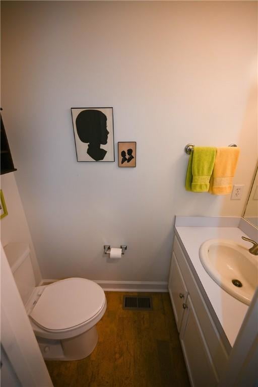 bathroom featuring baseboards, visible vents, toilet, and vanity