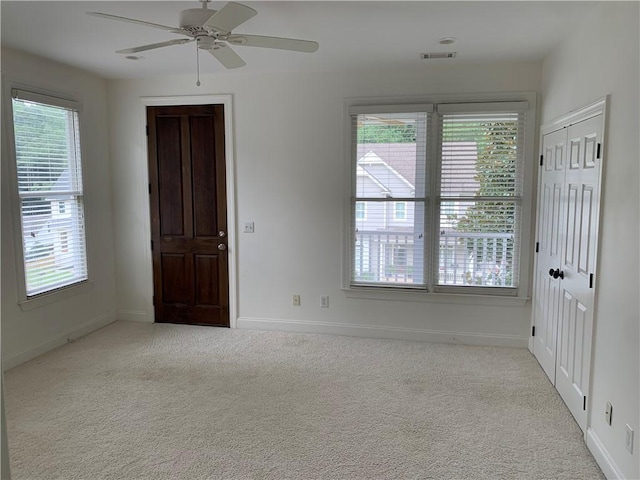 spare room featuring carpet floors, ceiling fan, and baseboards