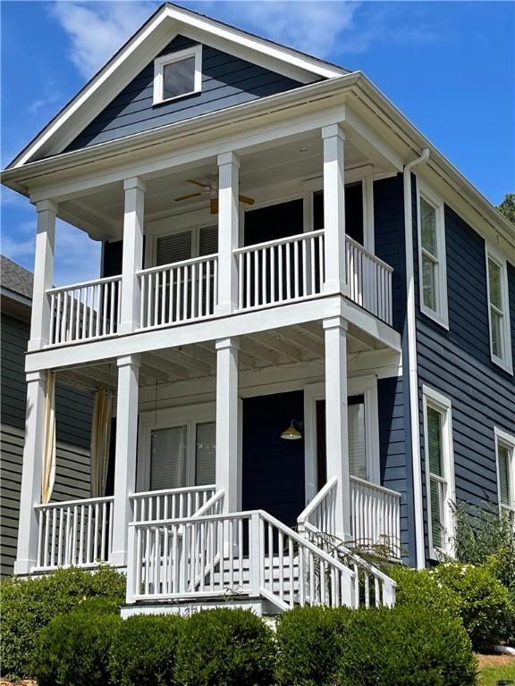 greek revival house featuring a balcony and a porch