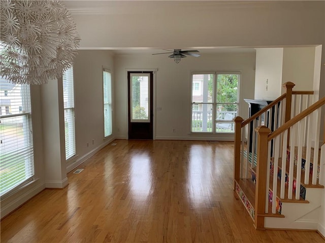 entrance foyer with light wood-style floors, baseboards, a ceiling fan, and ornamental molding