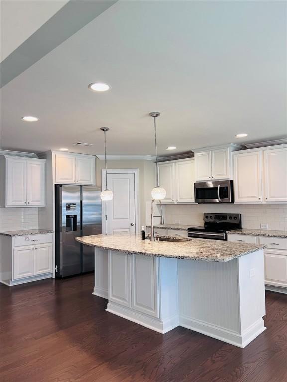 1024 Hampstead Ln, Opelika, AL 36801 - kitchen featuring appliances with stainless steel finishes, decorative backsplash, white cabinetry, recessed lighting, and a kitchen island with sink