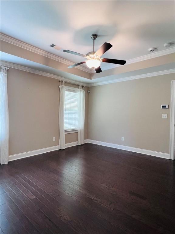 1024 Hampstead Ln, Opelika, AL 36801 - unfurnished room with crown molding, dark wood finished floors, a ceiling fan, and a raised ceiling