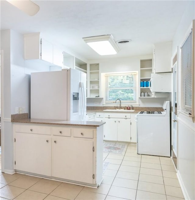 kitchen featuring white cabinets, white appliances, light tile patterned flooring, and sink