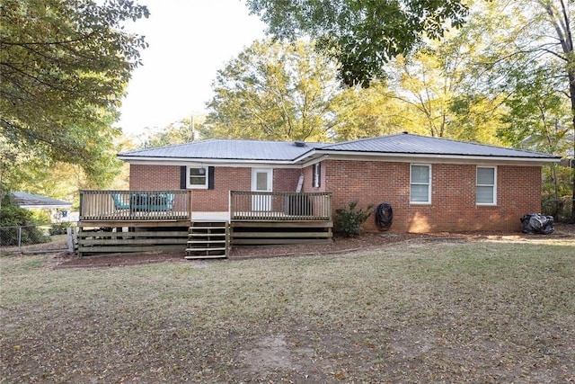 rear view of house with a wooden deck and a yard