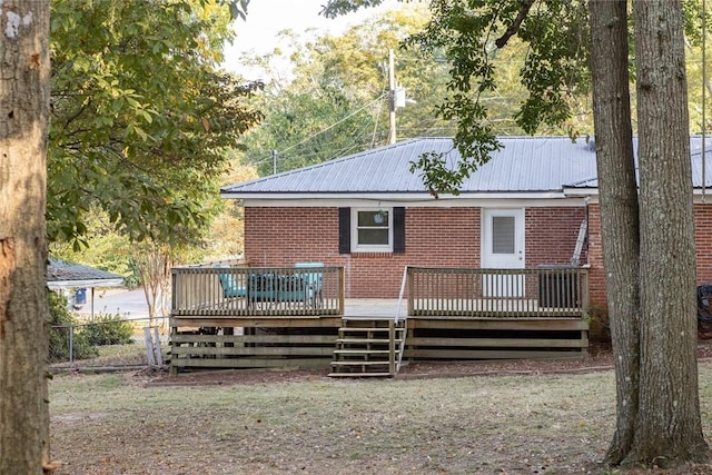 rear view of property featuring a lawn and a wooden deck