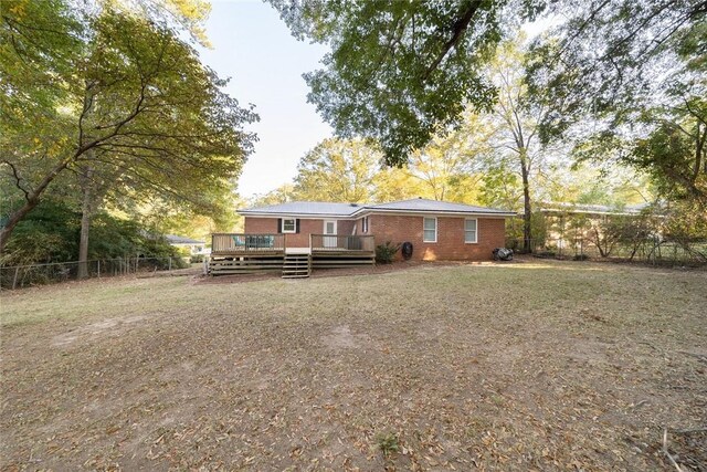 rear view of property featuring a wooden deck