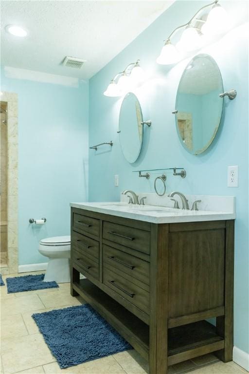 bathroom with tile patterned floors, a shower, vanity, and toilet