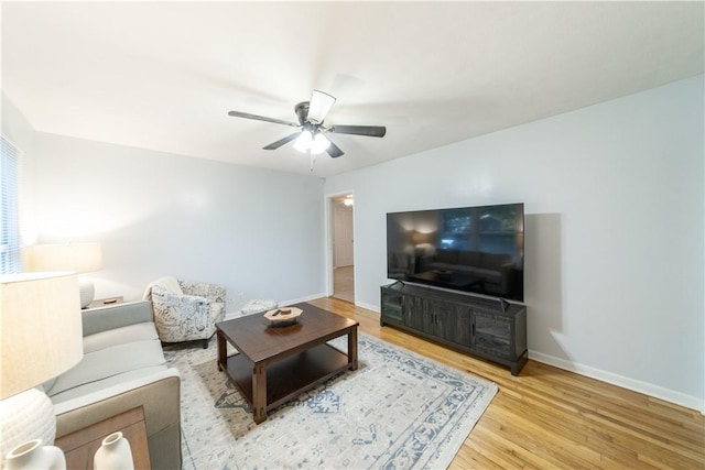 living room with light hardwood / wood-style flooring and ceiling fan