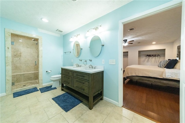 bathroom with vanity, a textured ceiling, toilet, and a shower with shower door