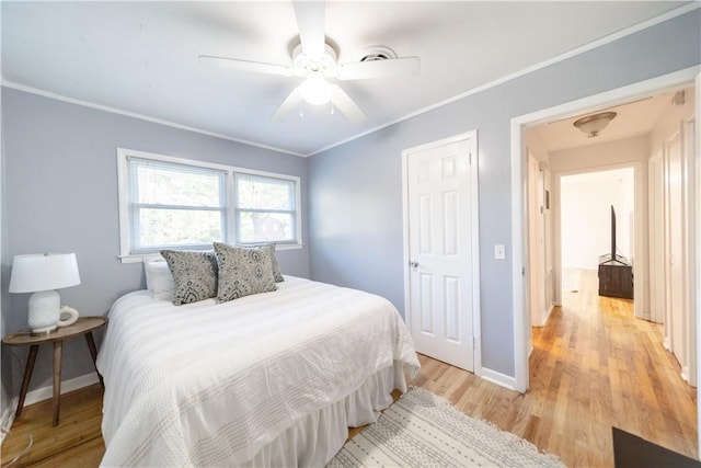 bedroom with light hardwood / wood-style flooring, ceiling fan, and ornamental molding