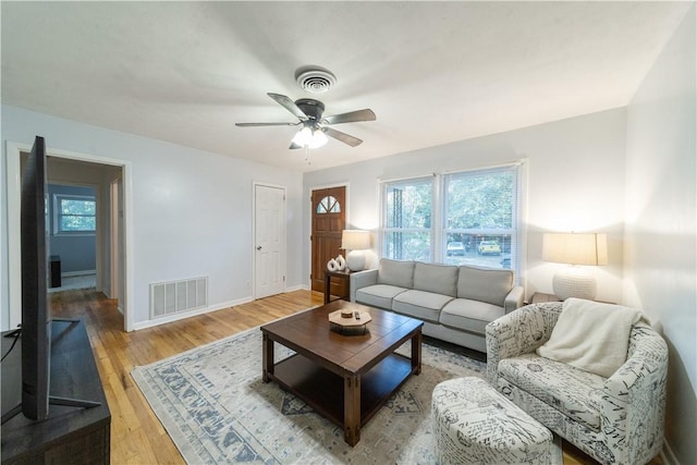 living room with wood-type flooring and ceiling fan