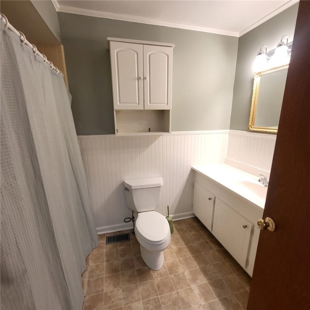 full bath featuring wainscoting, vanity, toilet, visible vents, and ornamental molding