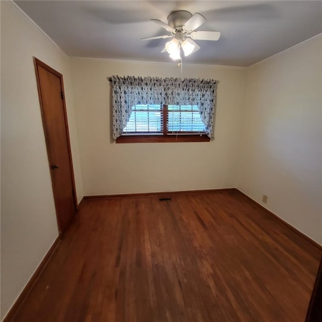 unfurnished room featuring a ceiling fan, baseboards, wood finished floors, visible vents, and ornamental molding