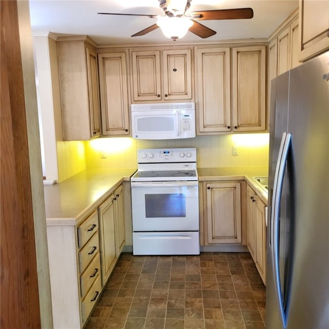 kitchen featuring light brown cabinets, white appliances, light countertops, a ceiling fan, and stone finish flooring