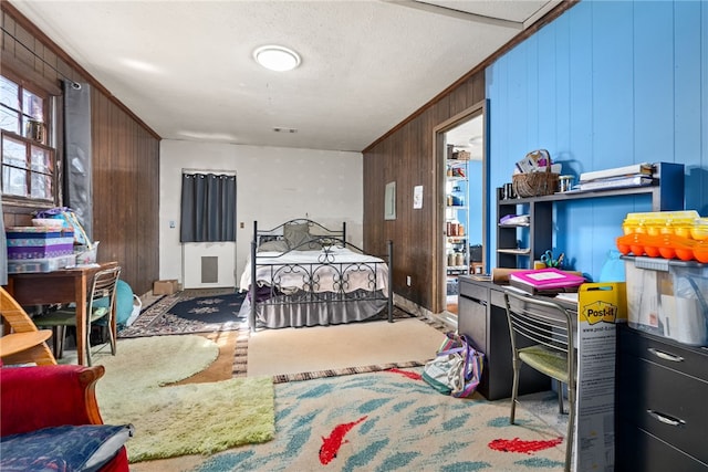 bedroom featuring a textured ceiling, wood walls, visible vents, and crown molding