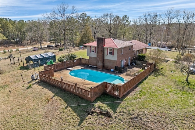 view of swimming pool with a fenced in pool, a patio, a lawn, fence, and a diving board