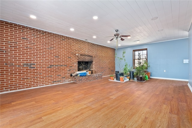 unfurnished living room featuring a ceiling fan, recessed lighting, brick wall, and wood finished floors