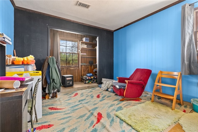 rec room with carpet floors, ornamental molding, visible vents, and wooden walls