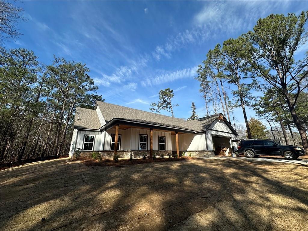 view of front of house featuring stone siding, a porch, board and batten siding, and an attached garage