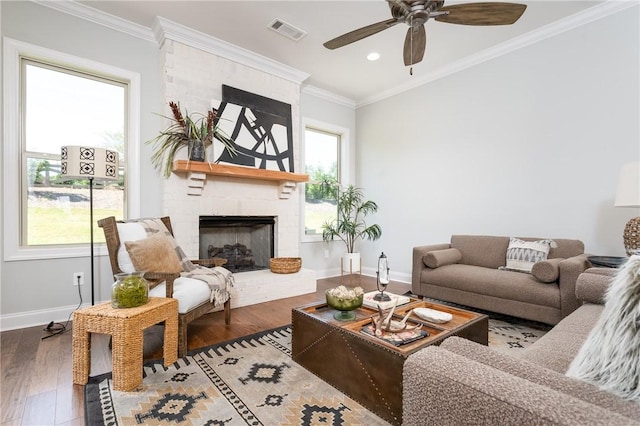 living room featuring hardwood / wood-style flooring, ceiling fan, ornamental molding, and a brick fireplace