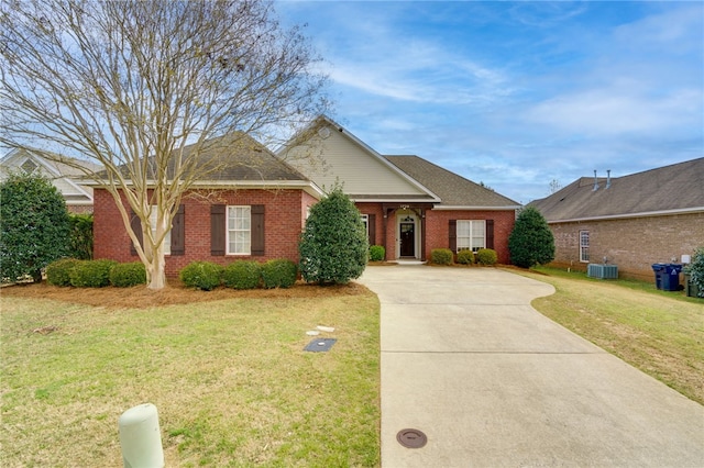 view of front of home featuring driveway, a front lawn, cooling unit, and brick siding