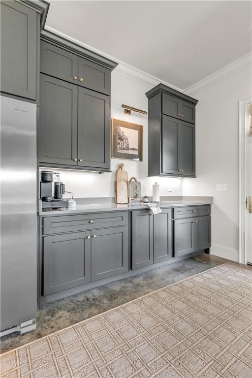 kitchen with ornamental molding, gray cabinetry, and stainless steel built in fridge