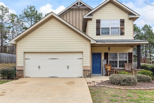 view of front facade featuring an attached garage, covered porch, stone siding, and driveway