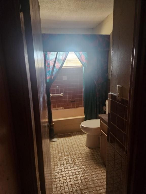 bathroom with a textured ceiling, toilet, vanity, tub / shower combination, and tile patterned floors