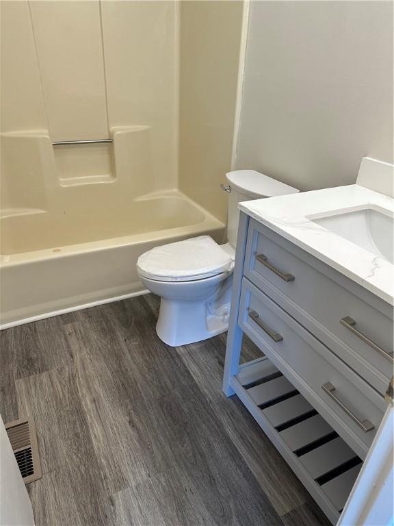 full bathroom featuring toilet, vanity, tub / shower combination, and hardwood / wood-style flooring